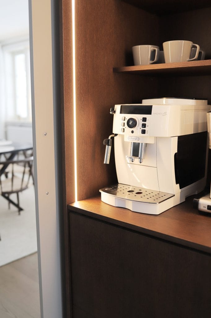 Kaffemaskin i öppet skåp med belysning